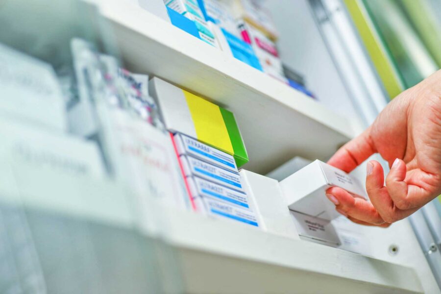 close up pharmacist hand holding medicine box pharmacy drugstore